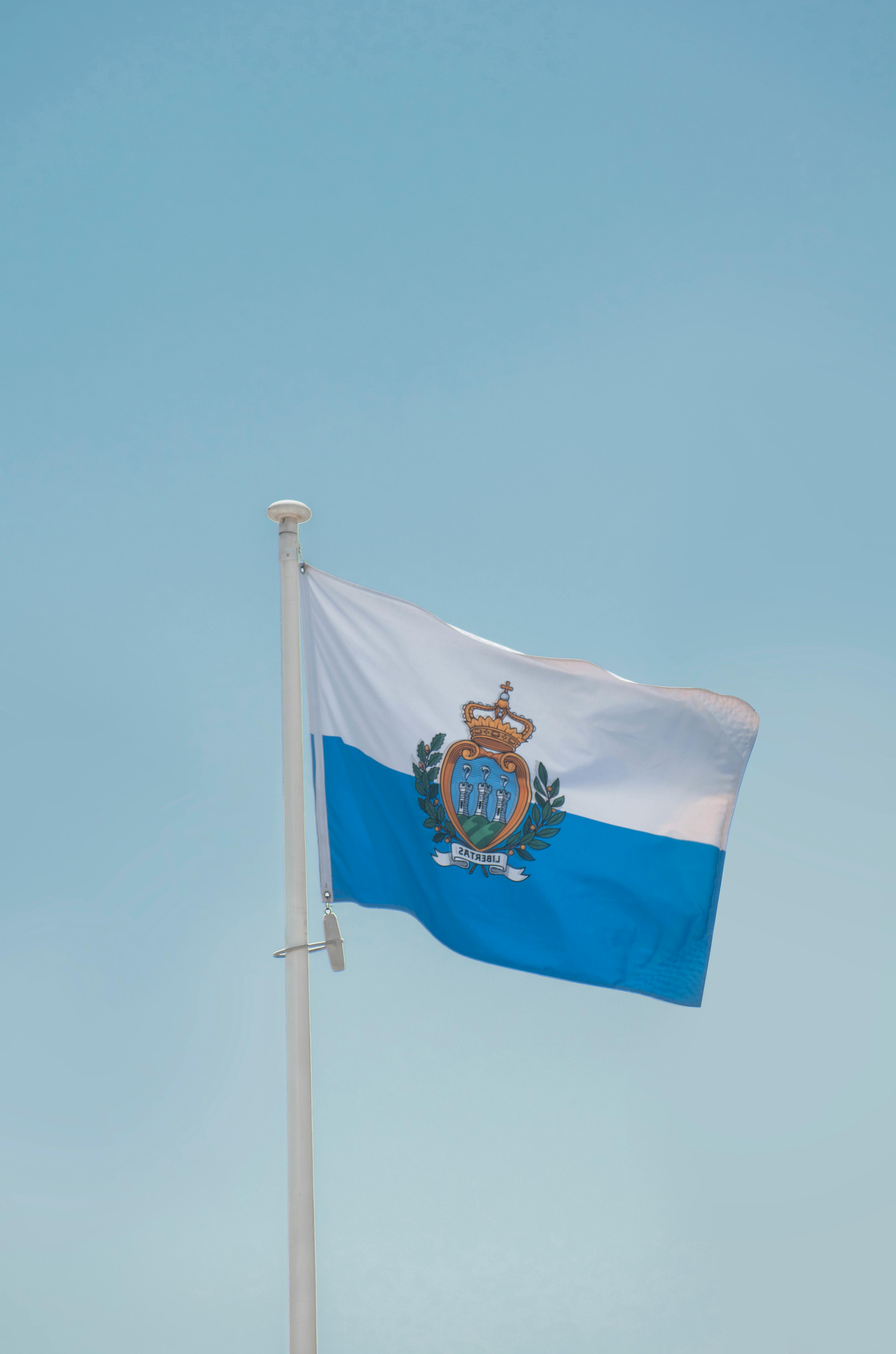 Flag of San Marino against a bright blue sky