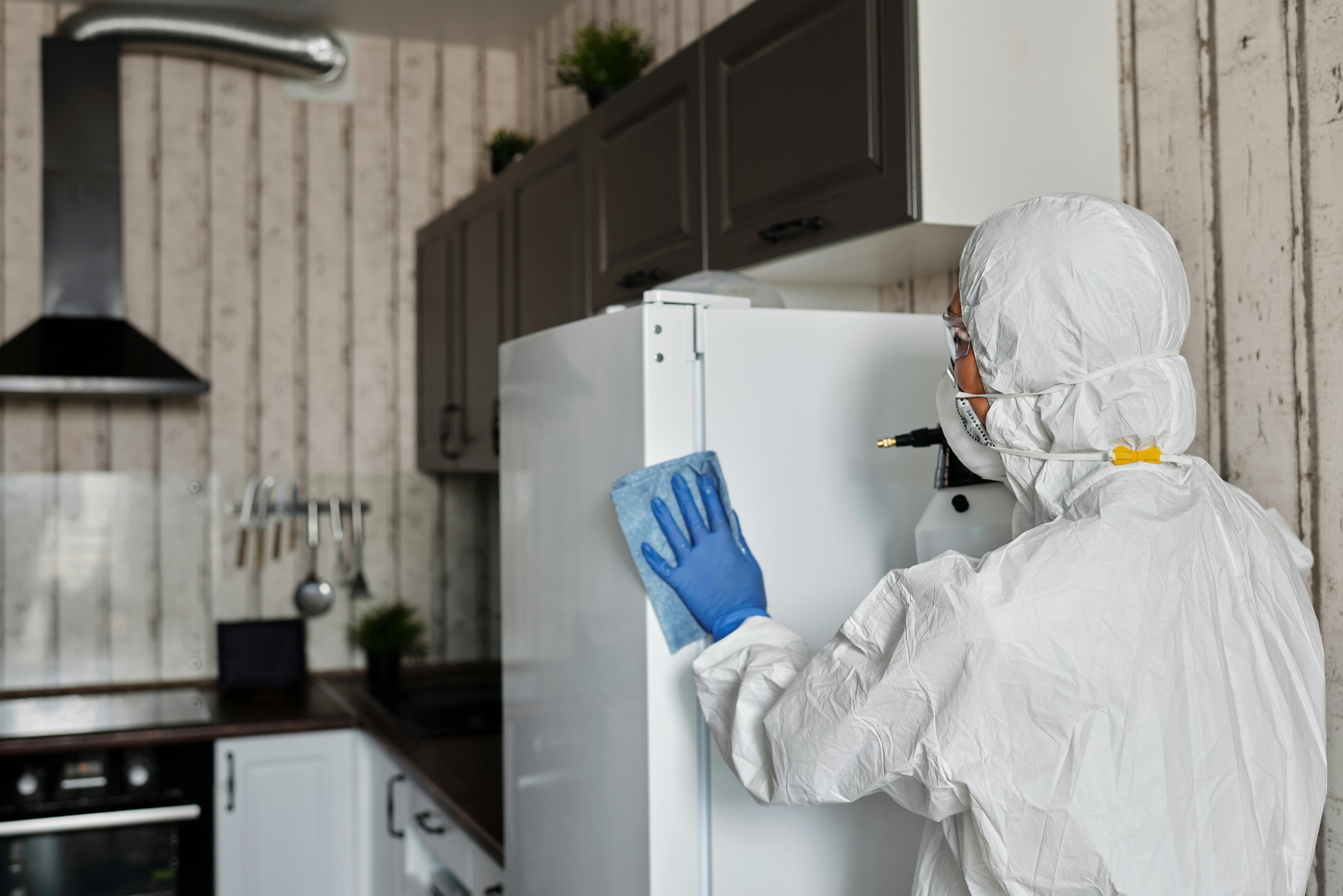 Woman sanitising kitchen with disinfecting wipes